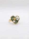Gold ring with green enamel and pearl on a white background