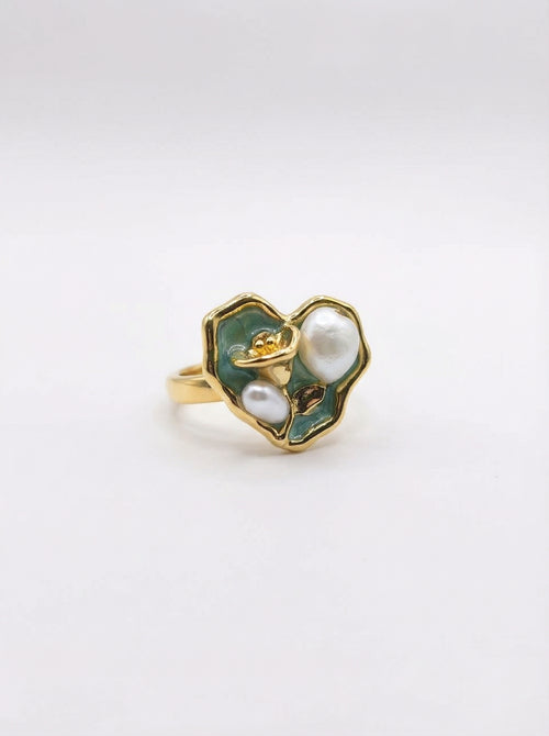 Gold ring with green enamel and pearl on a white background