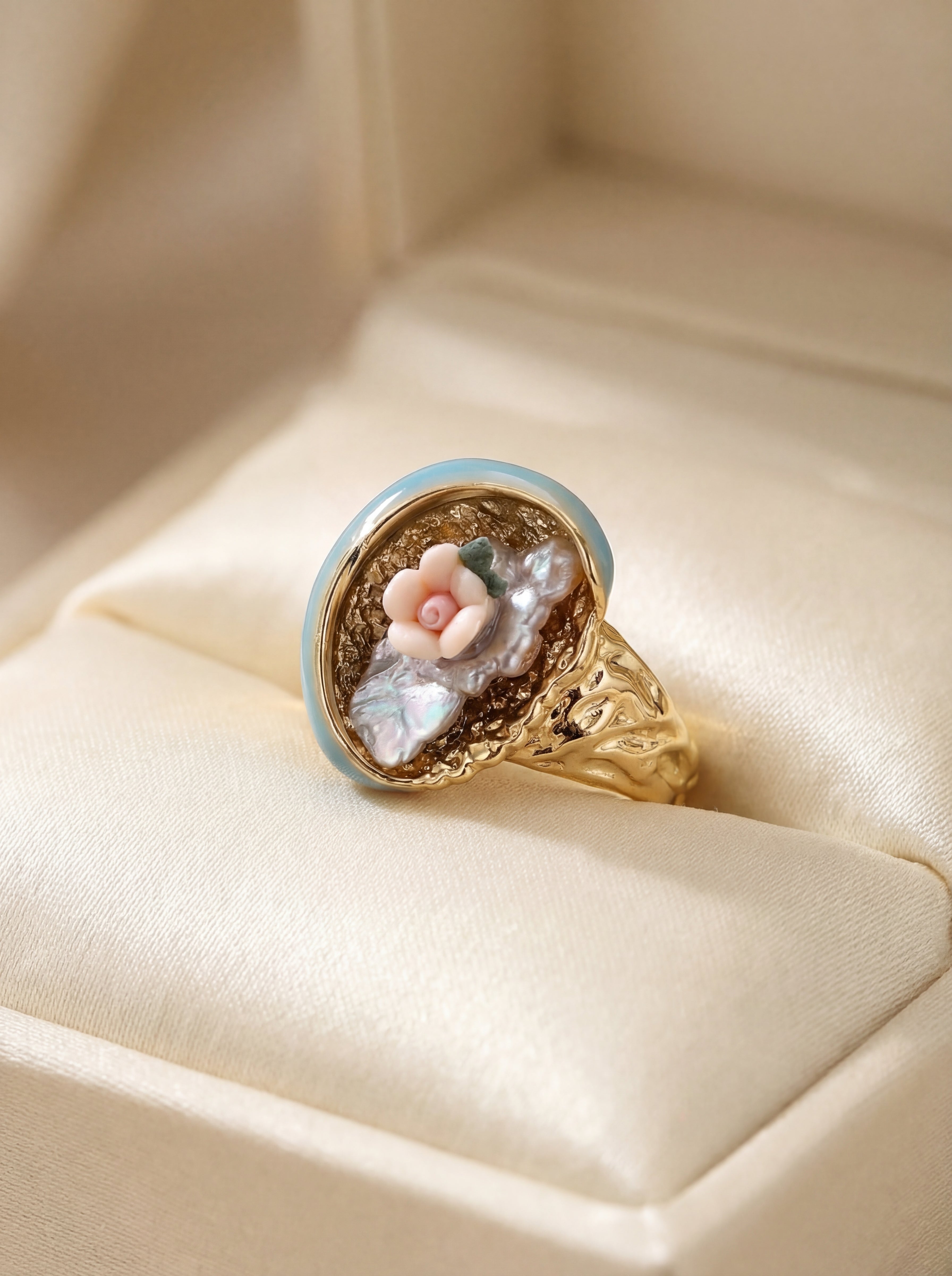 Gold ring with a floral design in a jewelry box