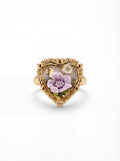 Heart-shaped gold ring with floral design on a white background
