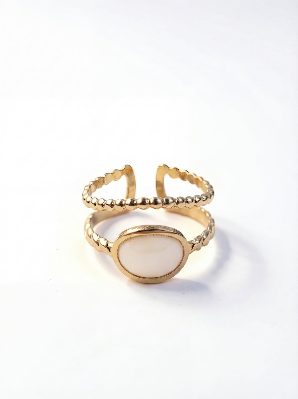 Gold ring with a white stone on a white background