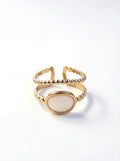 Gold ring with a white stone on a white background