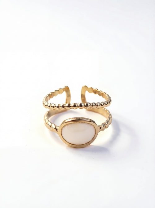 Gold ring with a white stone on a white background