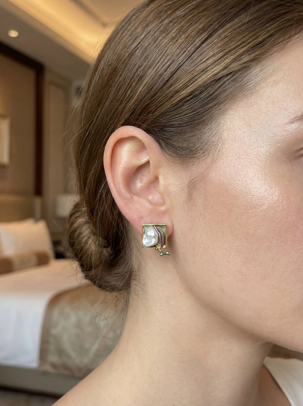 Close-up of a person wearing an earring with a blurred indoor background