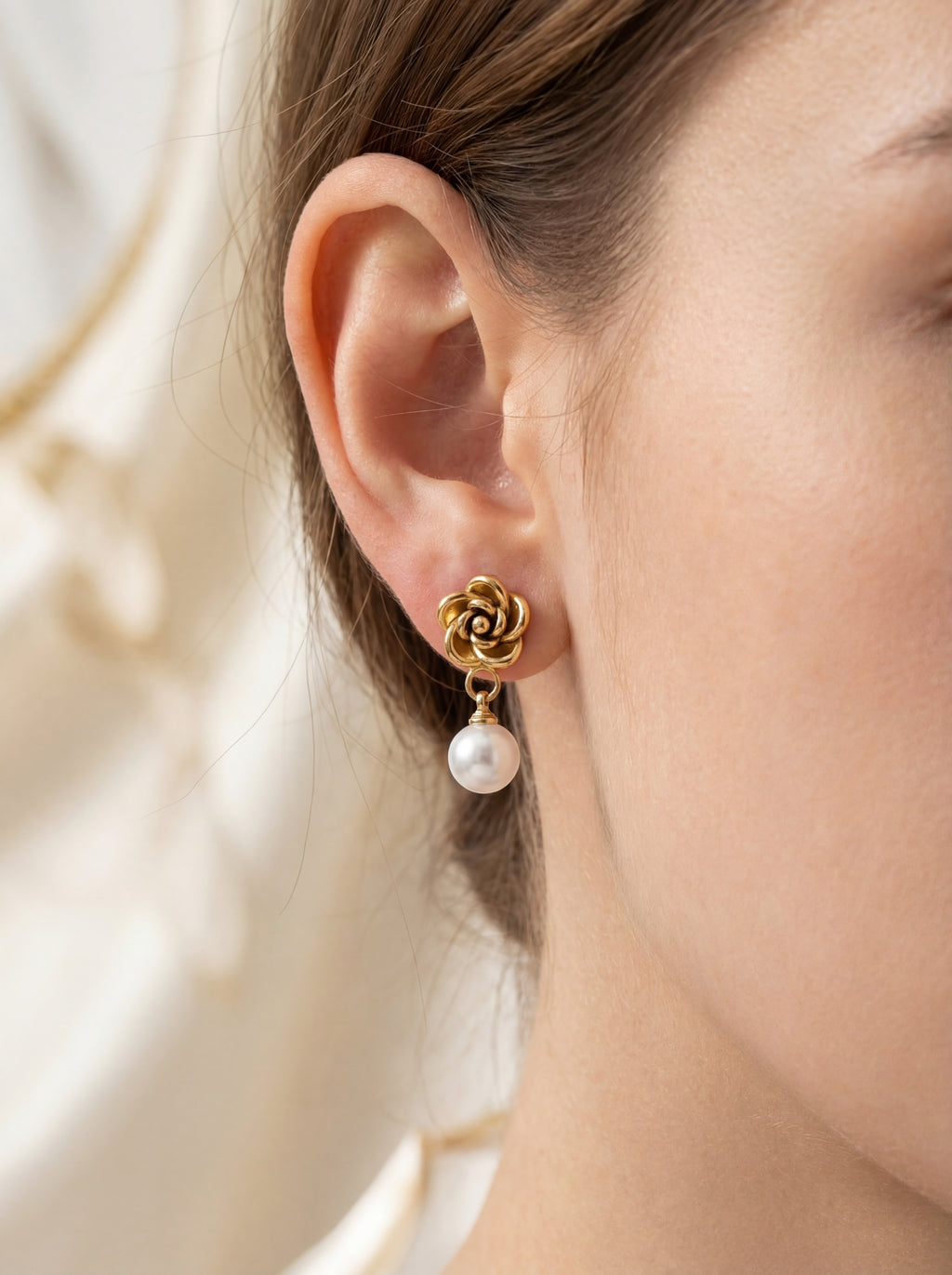 Person wearing gold flower-shaped earrings