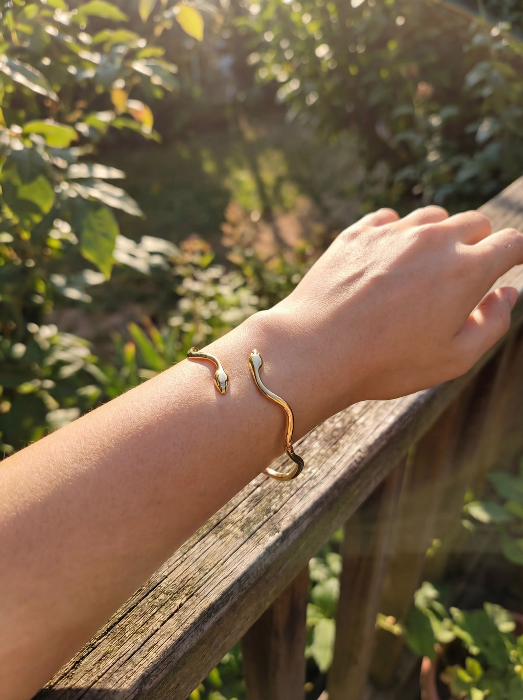 Person wearing a gold snake bangle