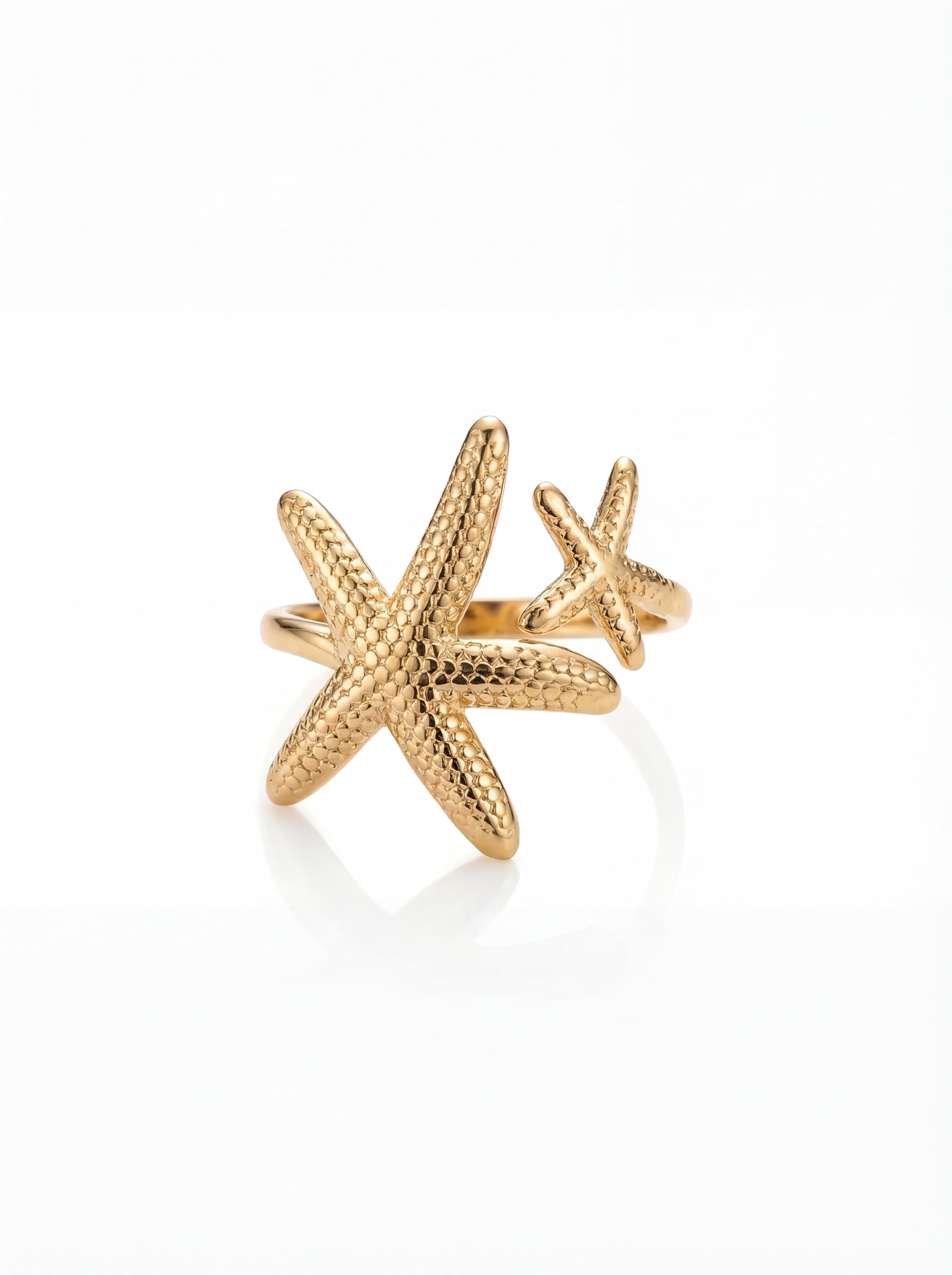 Gold starfish-shaped ring on a white background