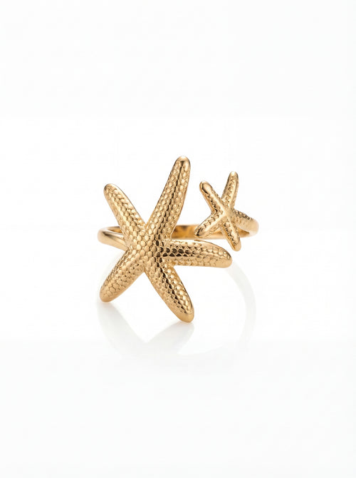 Gold starfish-shaped ring on a white background