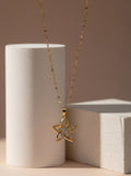 Gold necklace with a floral pendant on a neutral background