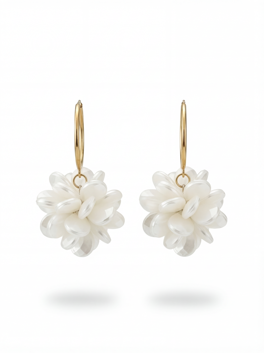 Pair of white floral earrings with gold hooks on a white background