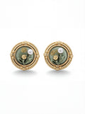 Pair of gold earrings with green stones and pearls on a white background