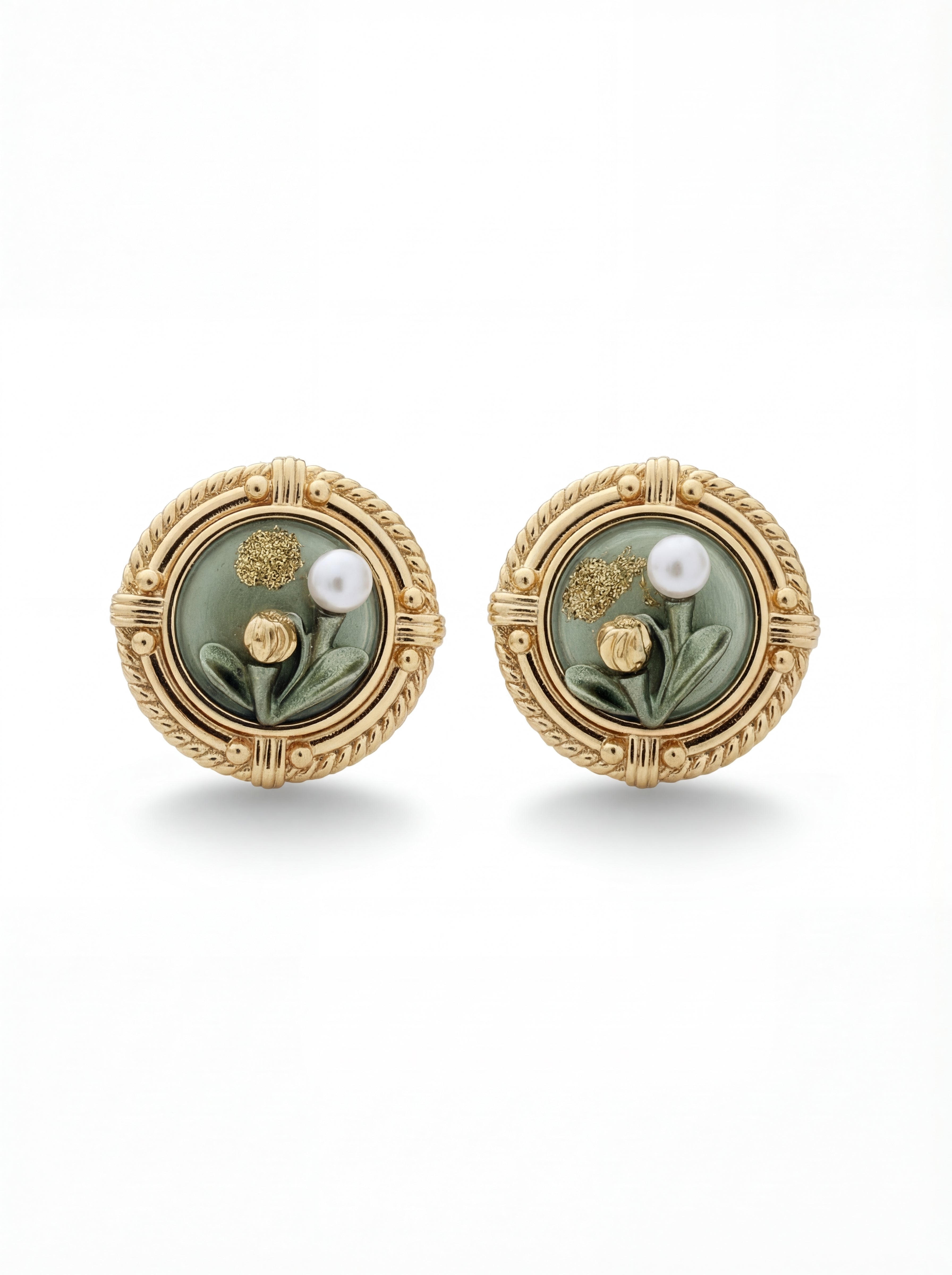 Pair of gold earrings with green stones and pearls on a white background