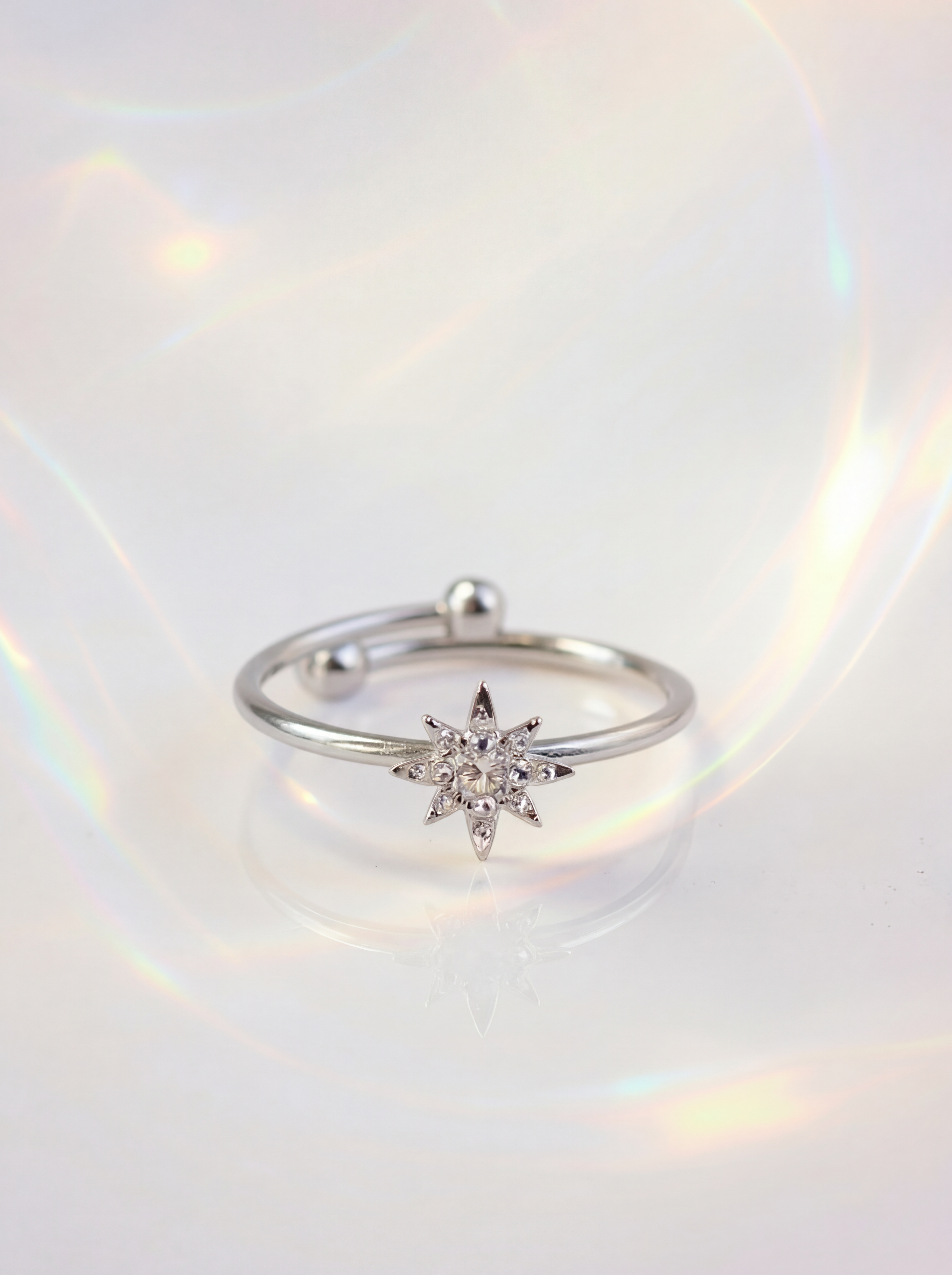 Silver ring with a star-shaped diamond on a white background
