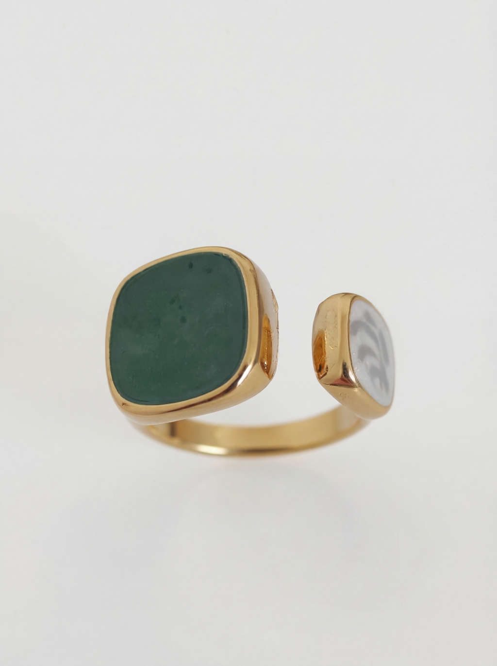 Gold ring with a green stone on a white background