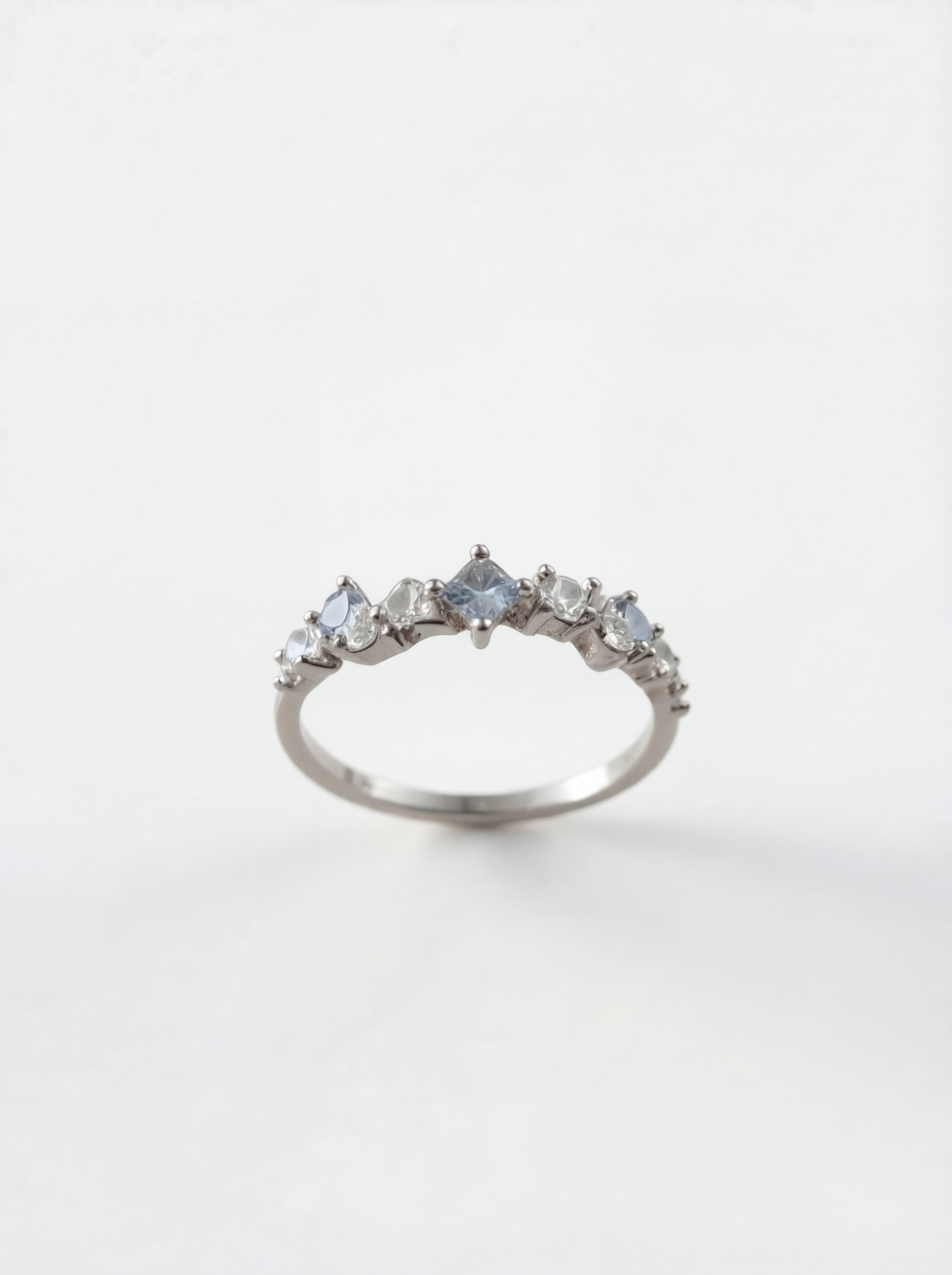 Silver ring with multiple gemstones on a white background