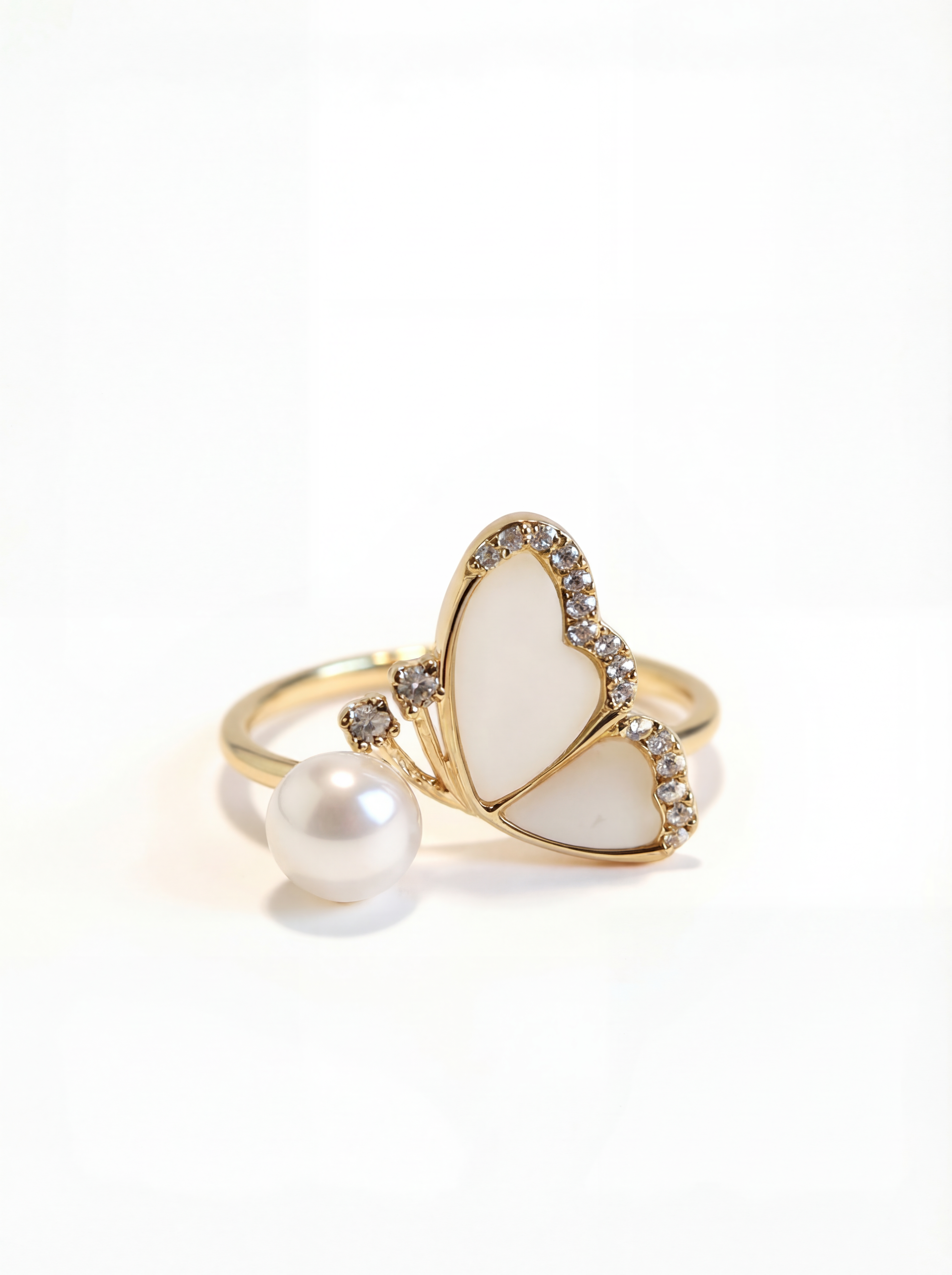 Heart-shaped ring with pearl and gold accents on a white background
