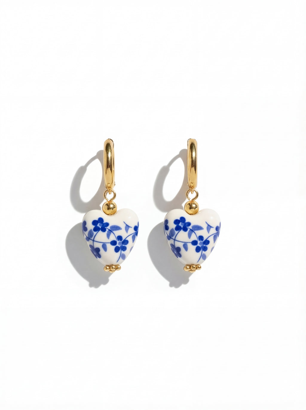 Pair of earrings with blue floral design on a white background