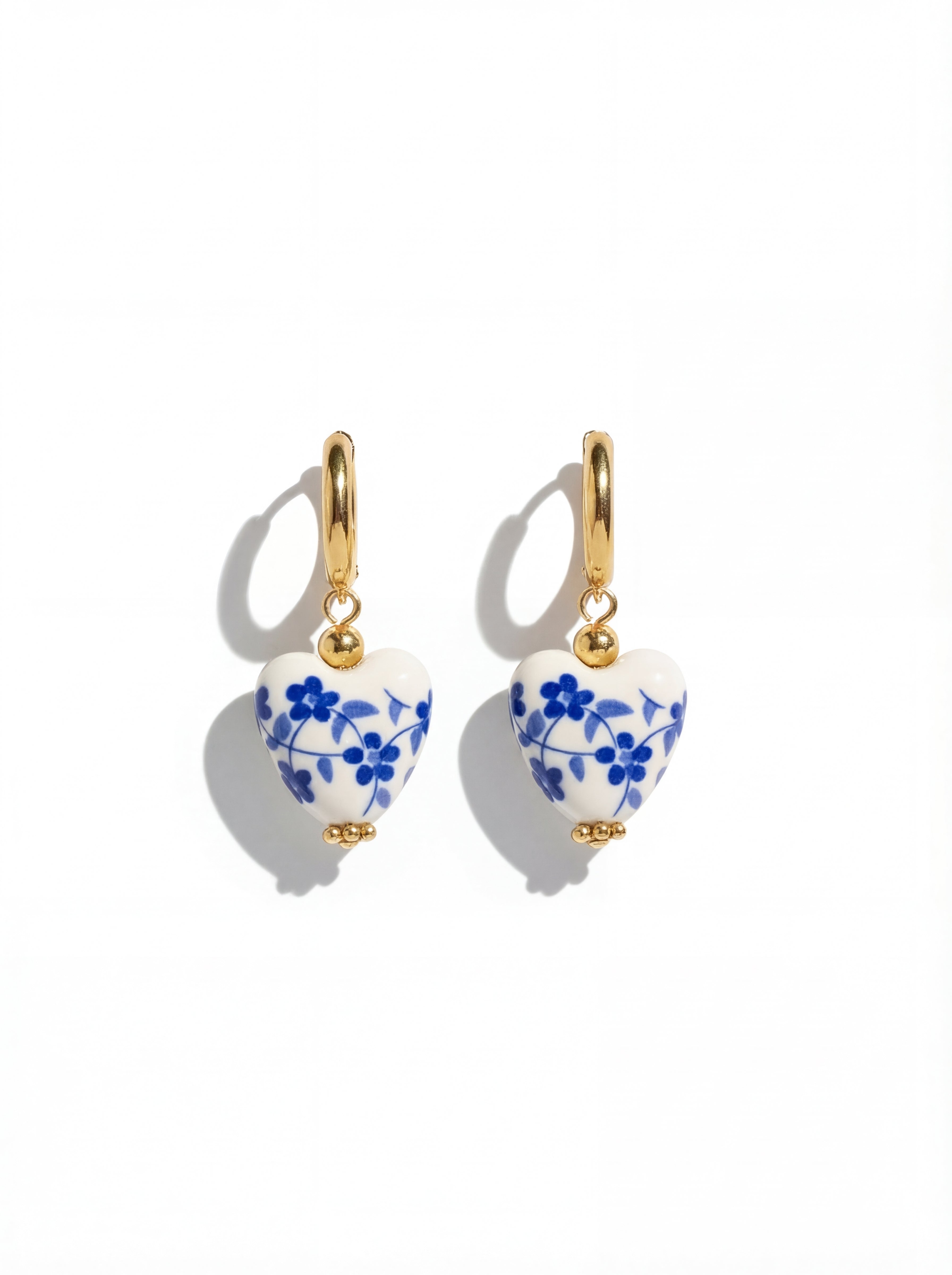 Pair of earrings with blue floral design on a white background