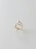 Gold ring with pearls on a light gray background