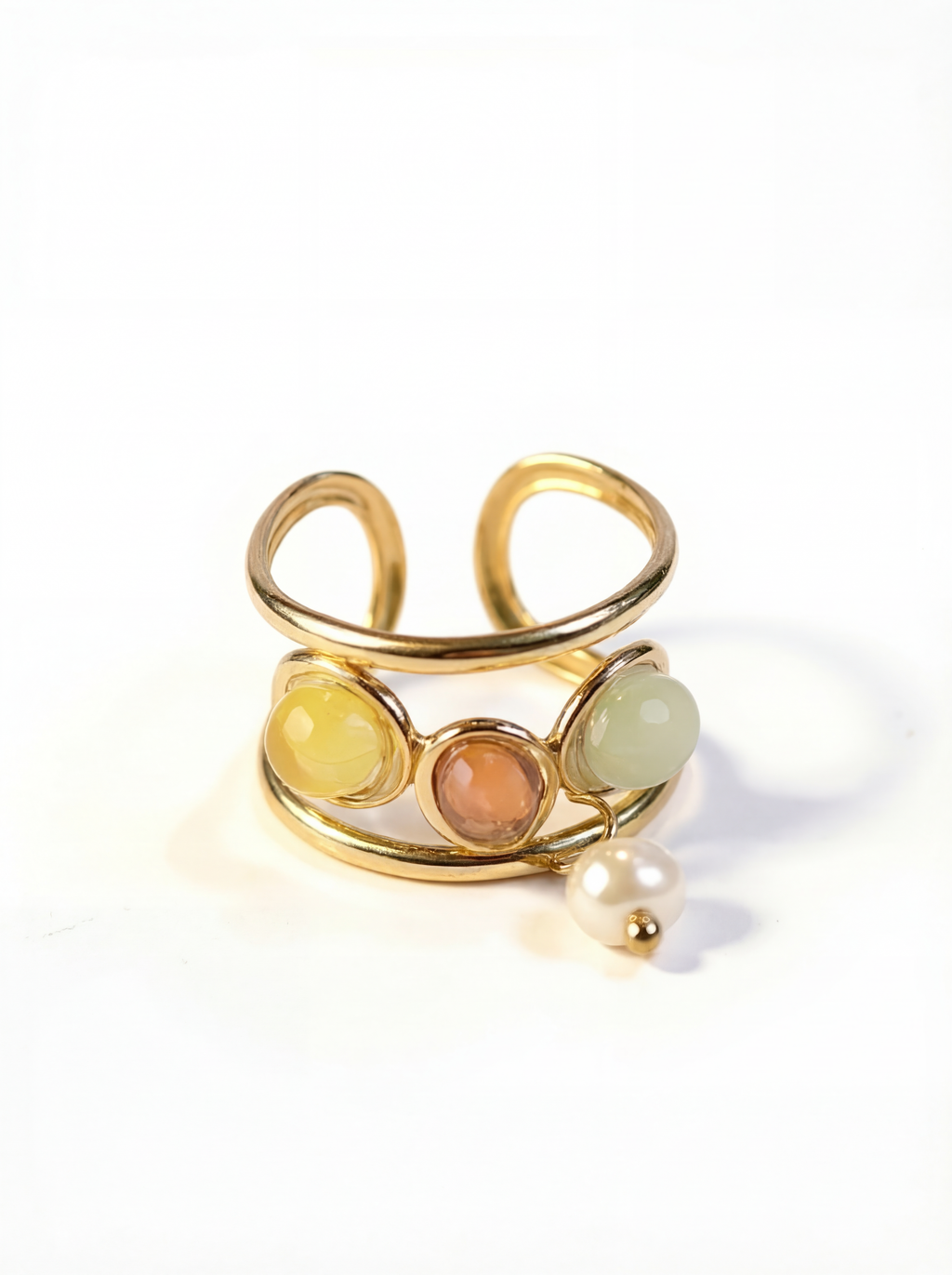 Gold ring with colored stones and a pearl on a white background
