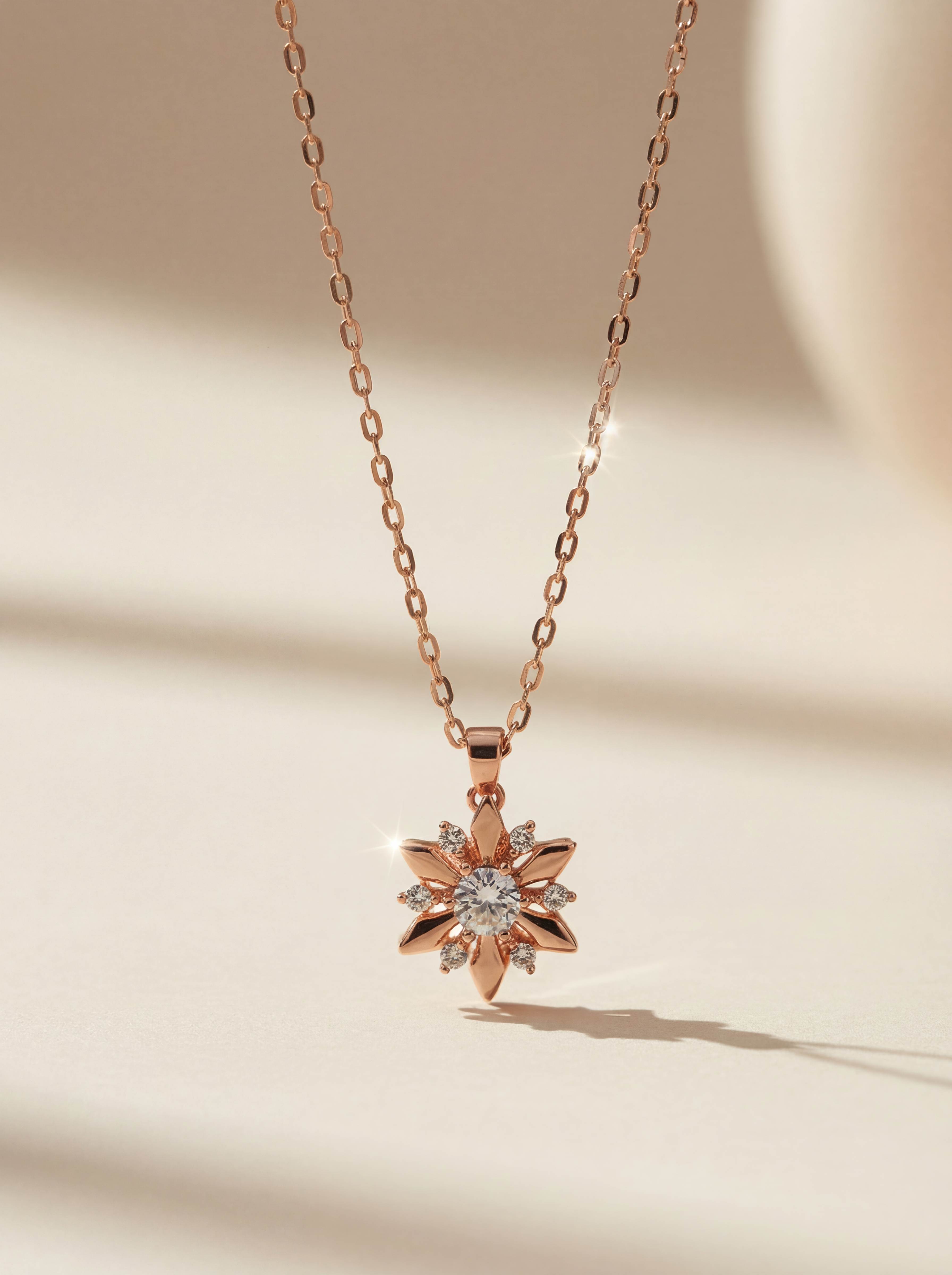 Rose gold necklace with a star-shaped pendant on a beige background