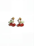 Cherry-themed earrings with red stones and gold accents on a white background
