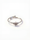 Silver ring with a star-shaped diamond on a white background