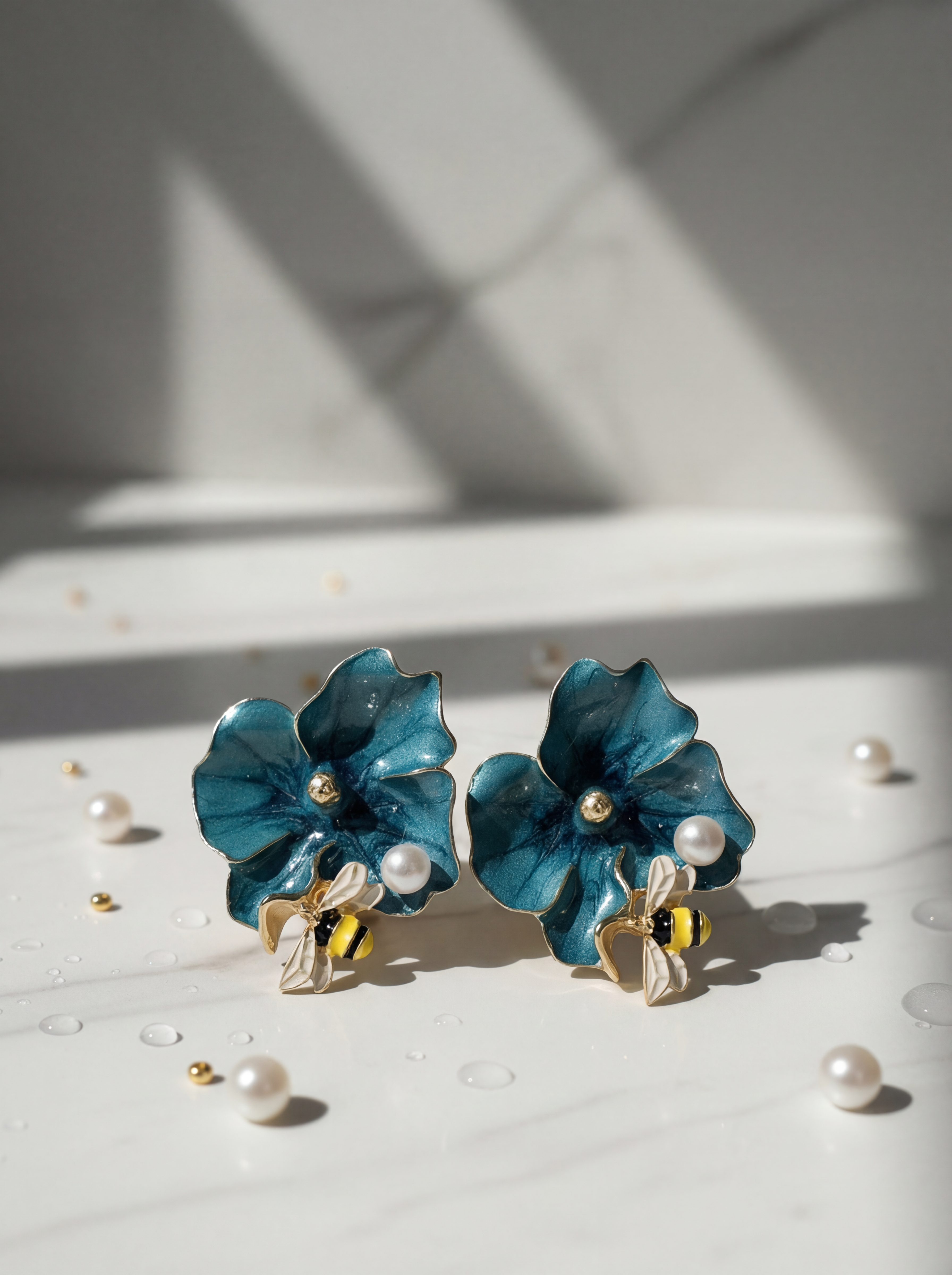 Blue flower earrings with pearl accents on a light surface.