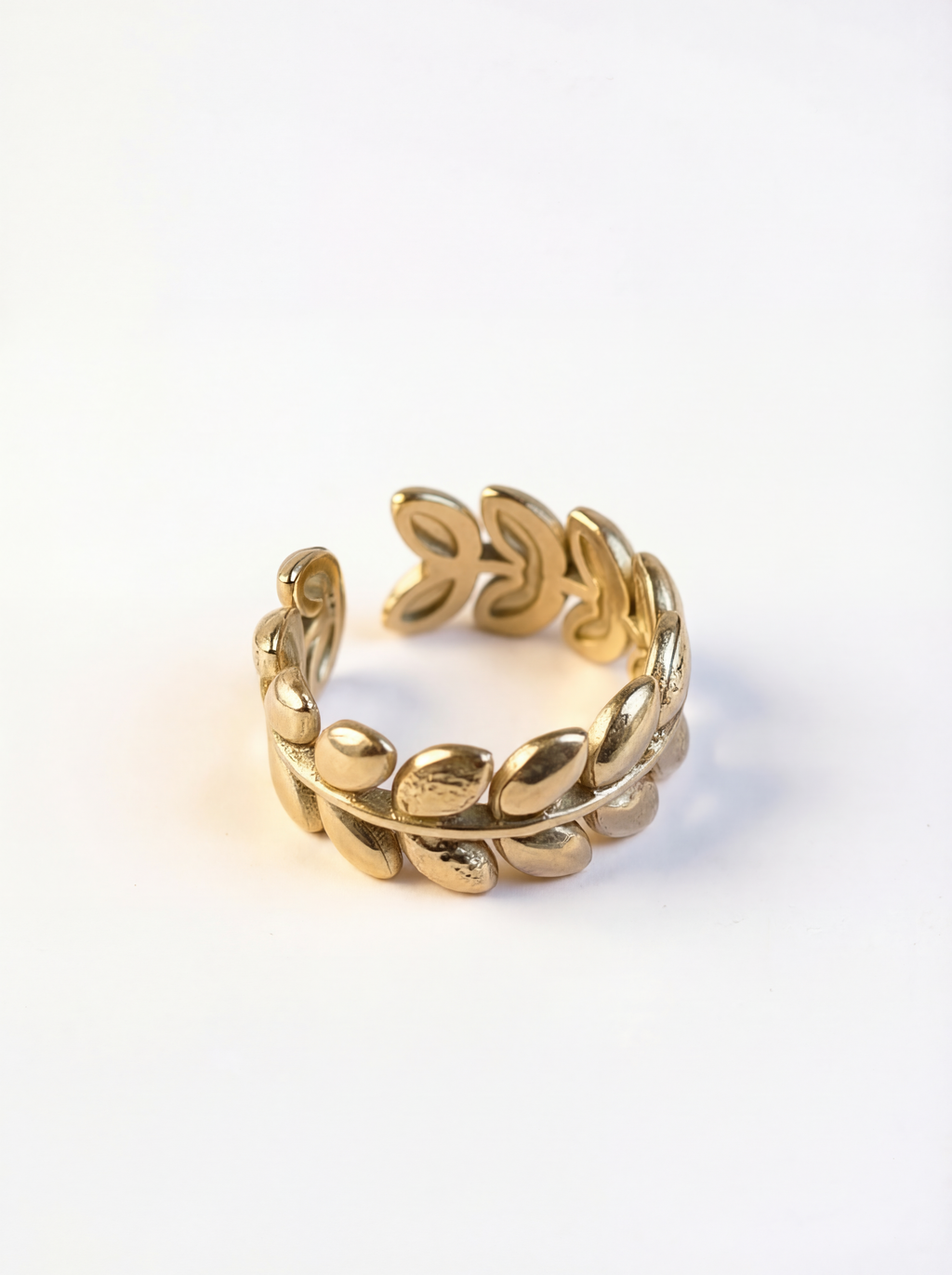 Gold ring with leaf design on a white background