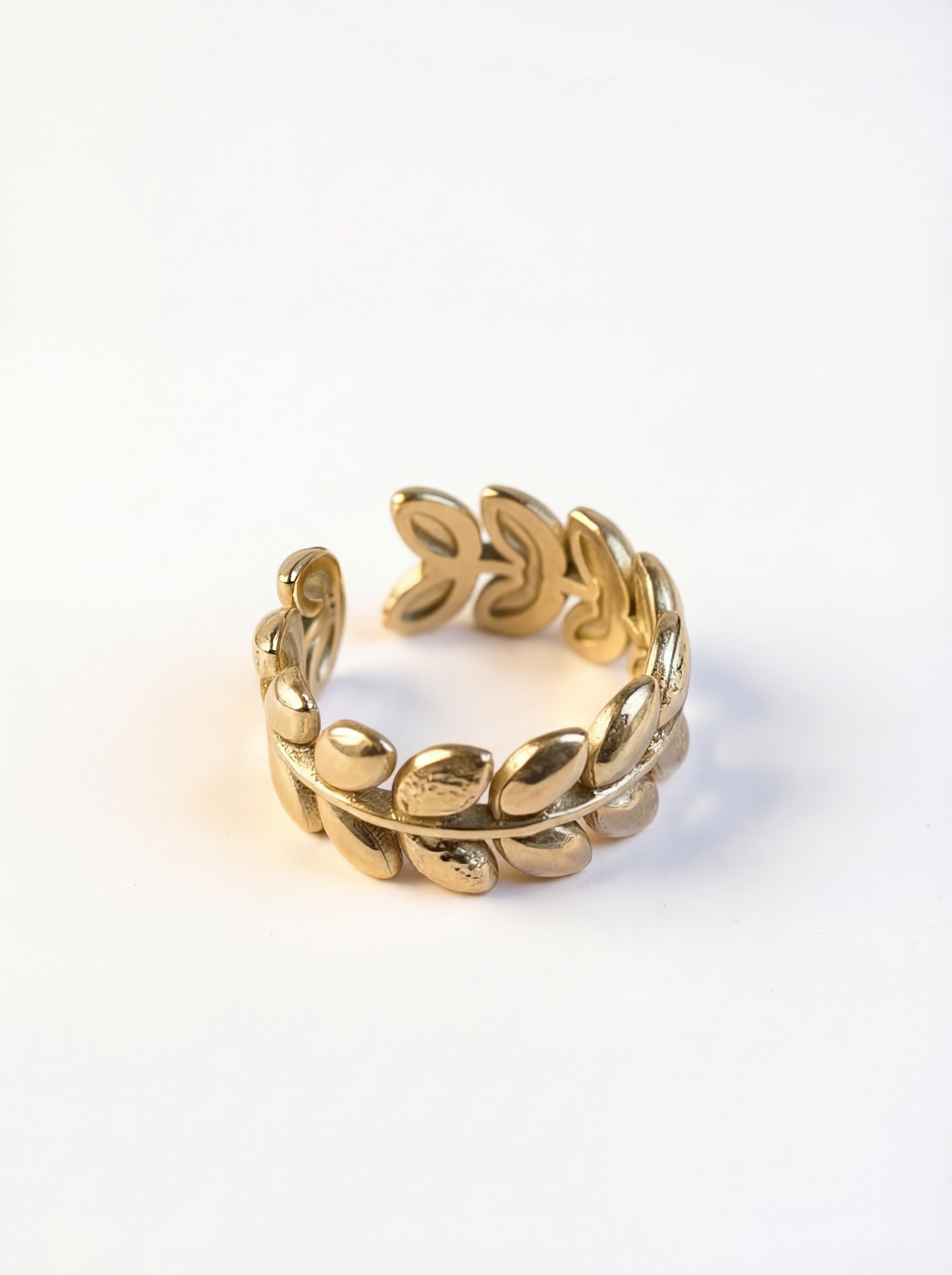 Gold ring with leaf design on a white background