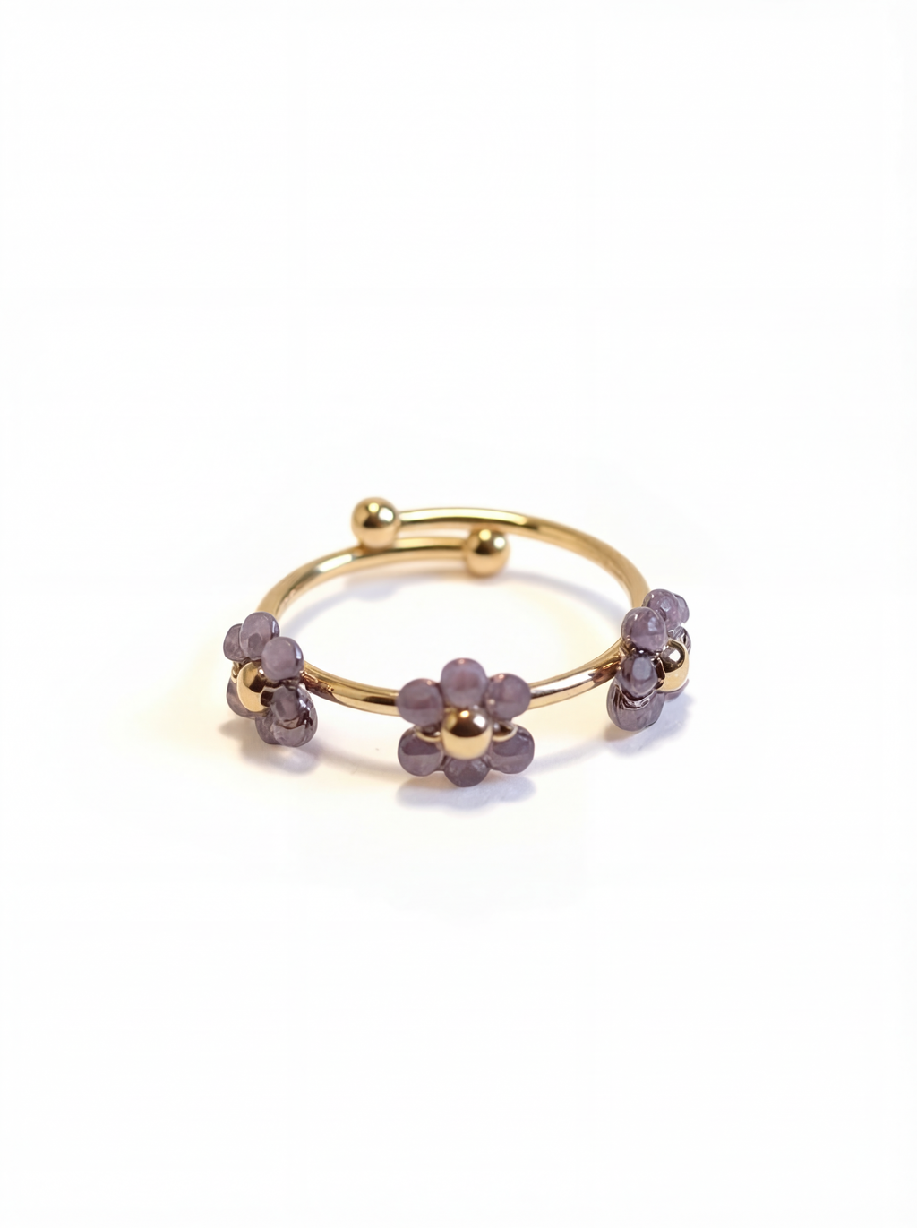 Gold ring with purple gemstones on a white background