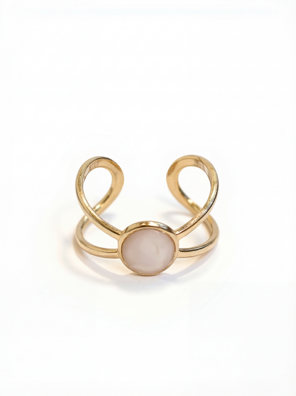 Gold ring with a central gemstone on a white background