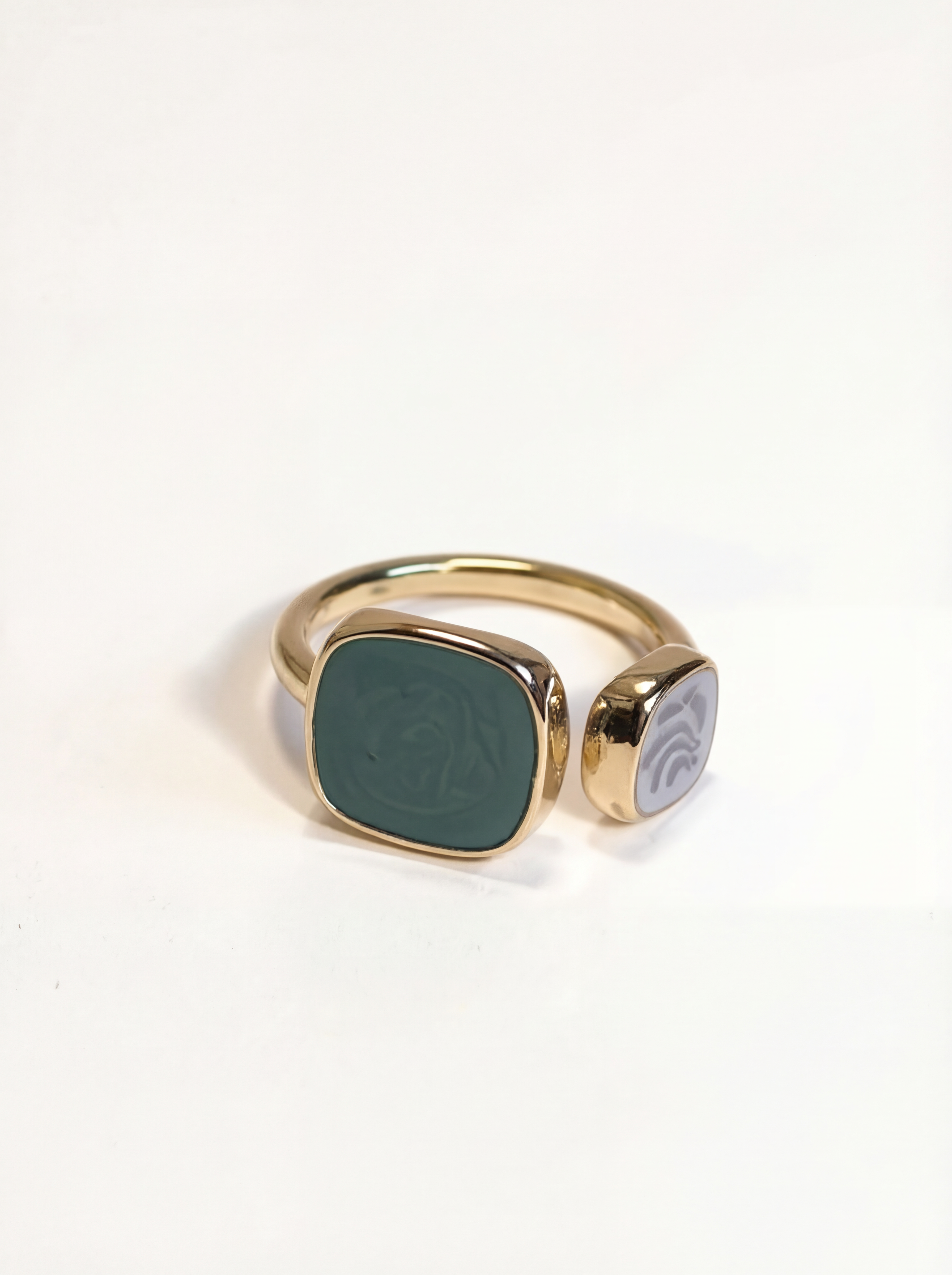 Gold ring with a green stone on a white background