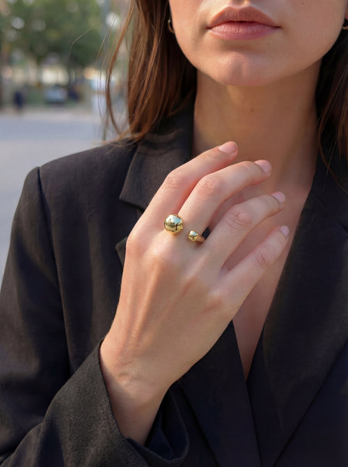 Close-up of a person wearing a gold ring outdoors