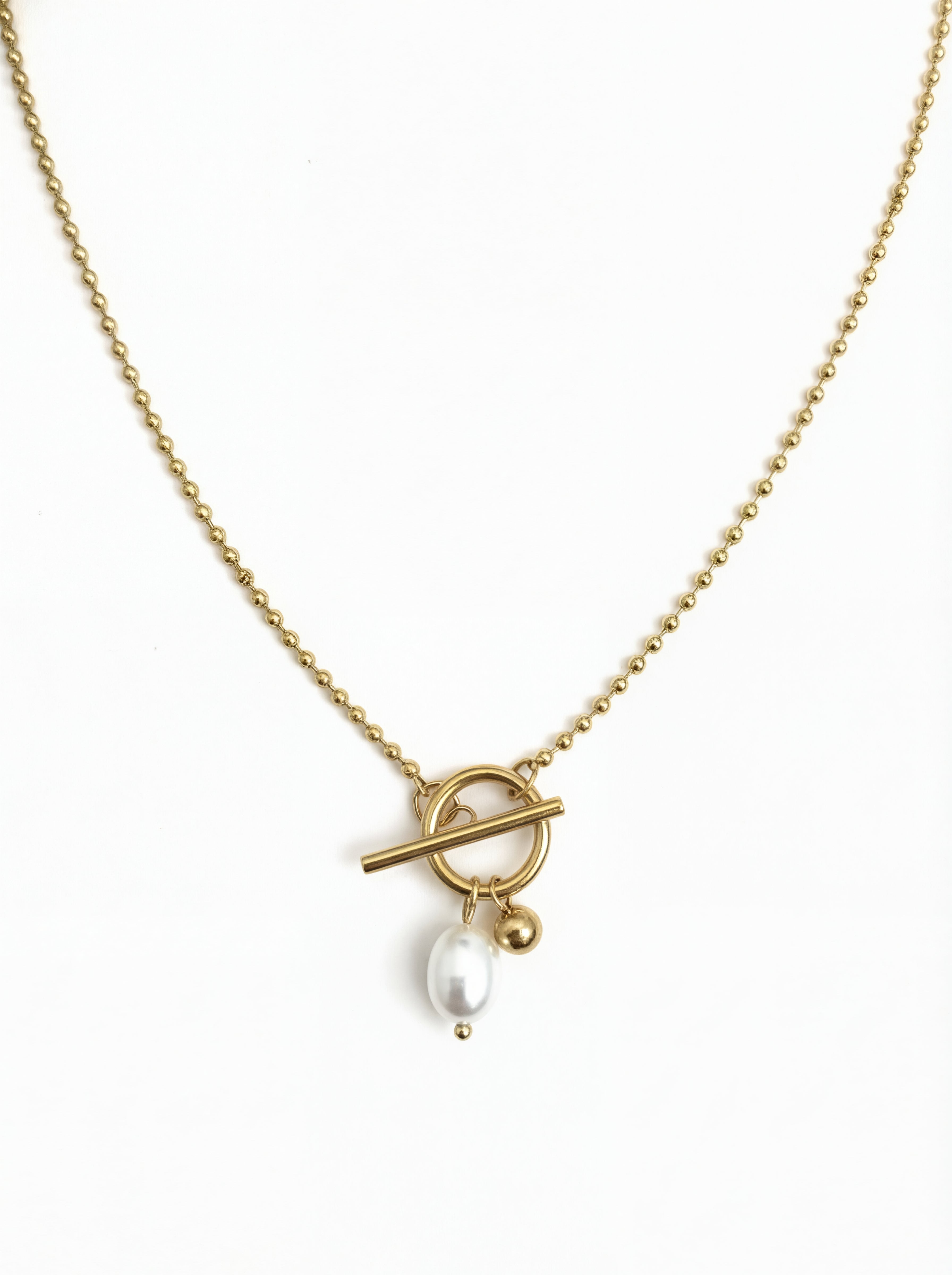 Gold necklace with a toggle clasp and pearl pendant on a white background