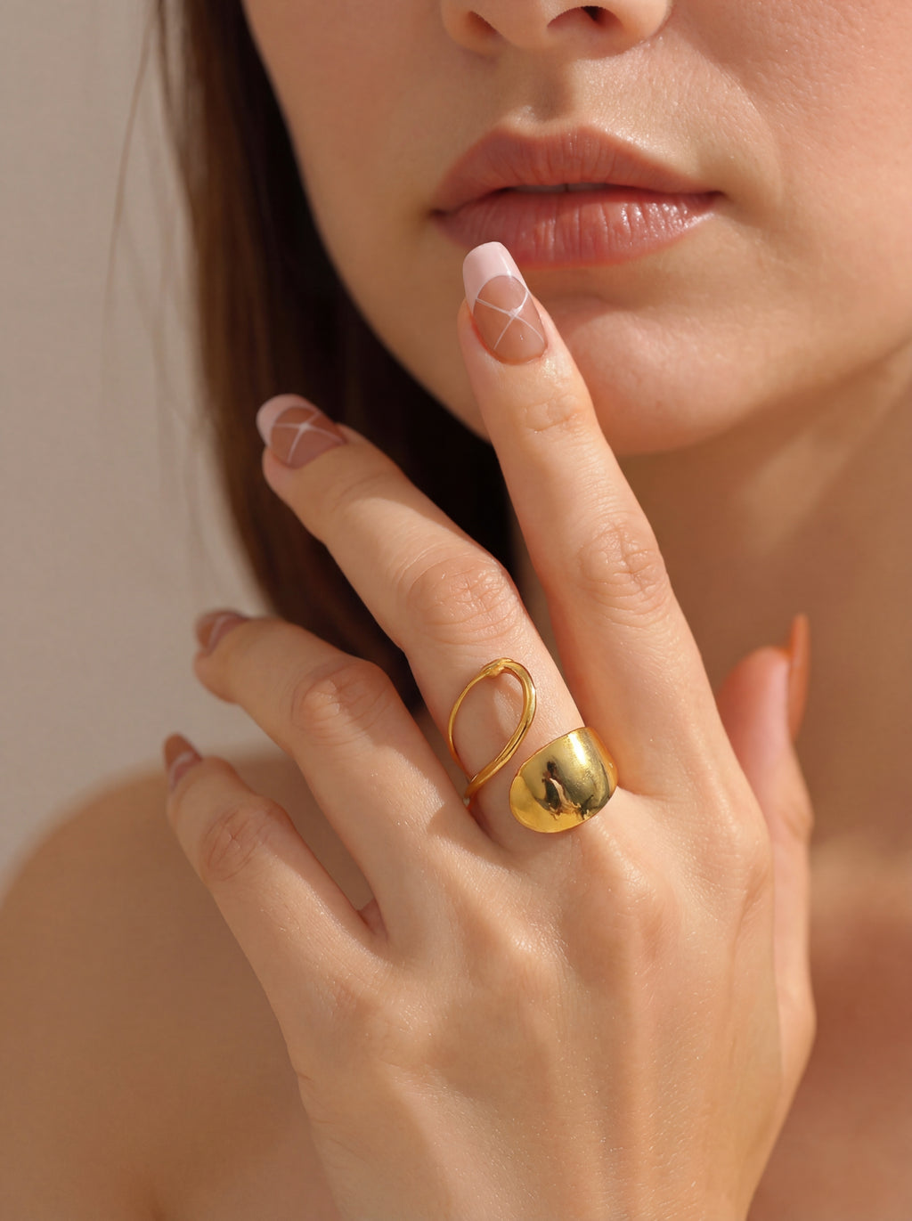Close-up of a hand wearing a gold ring with a blurred background