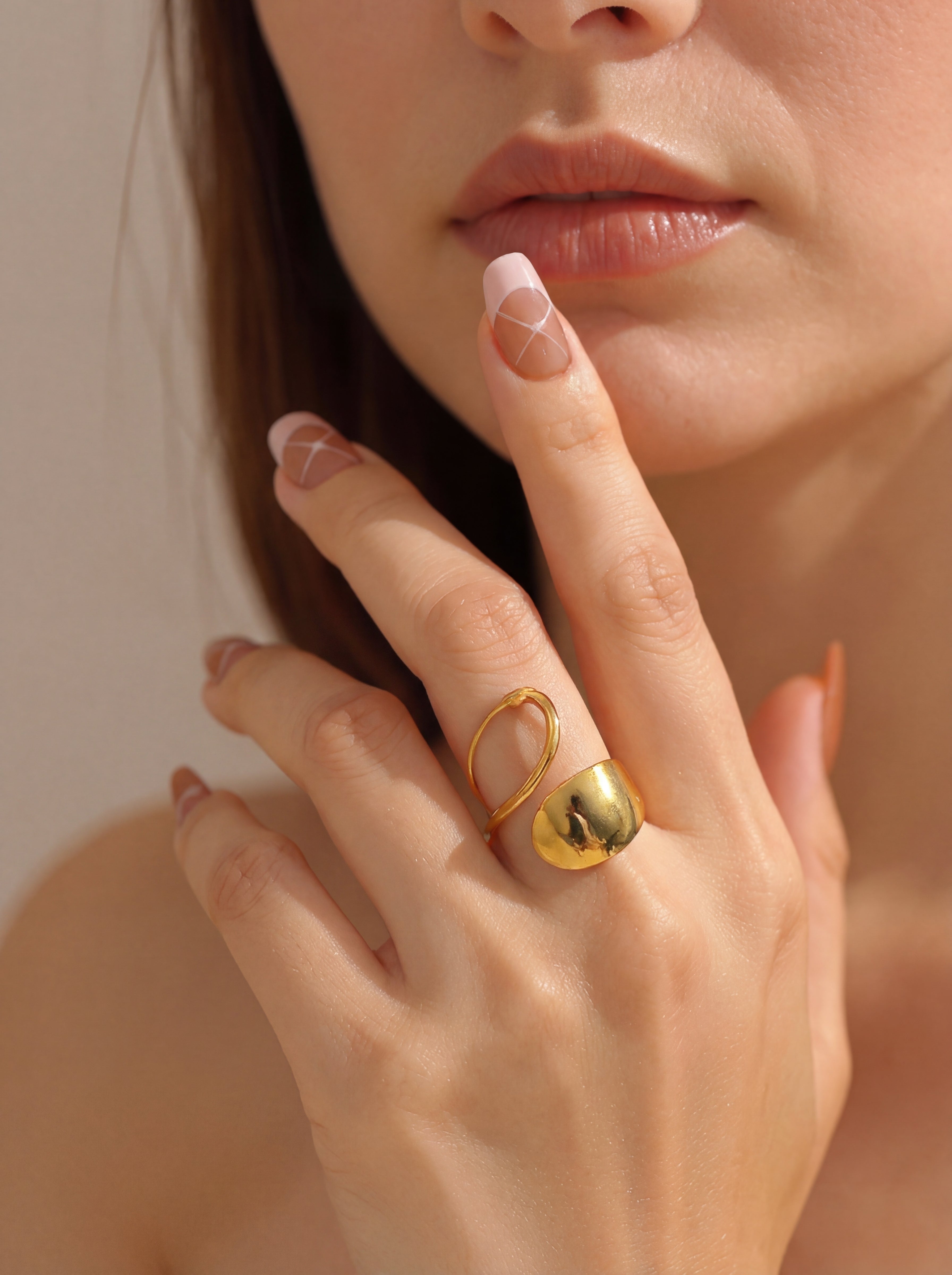 Close-up of a hand wearing a gold ring with a blurred background