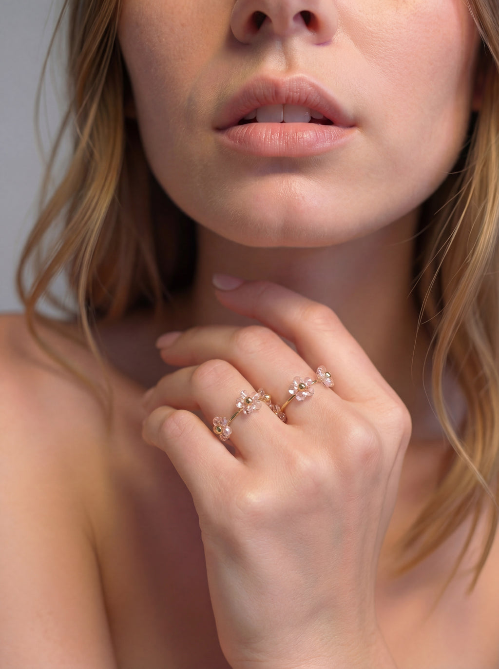 Close-up of a woman's hand wearing a delicate ring with floral design.