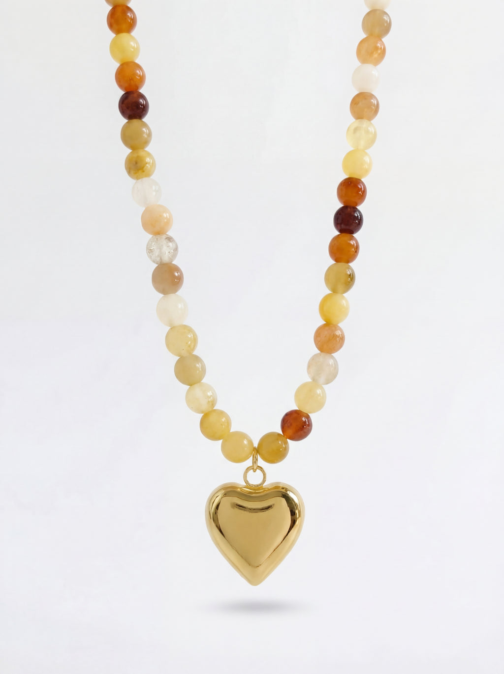 Necklace with multicolored beads and a gold heart pendant on a white background
