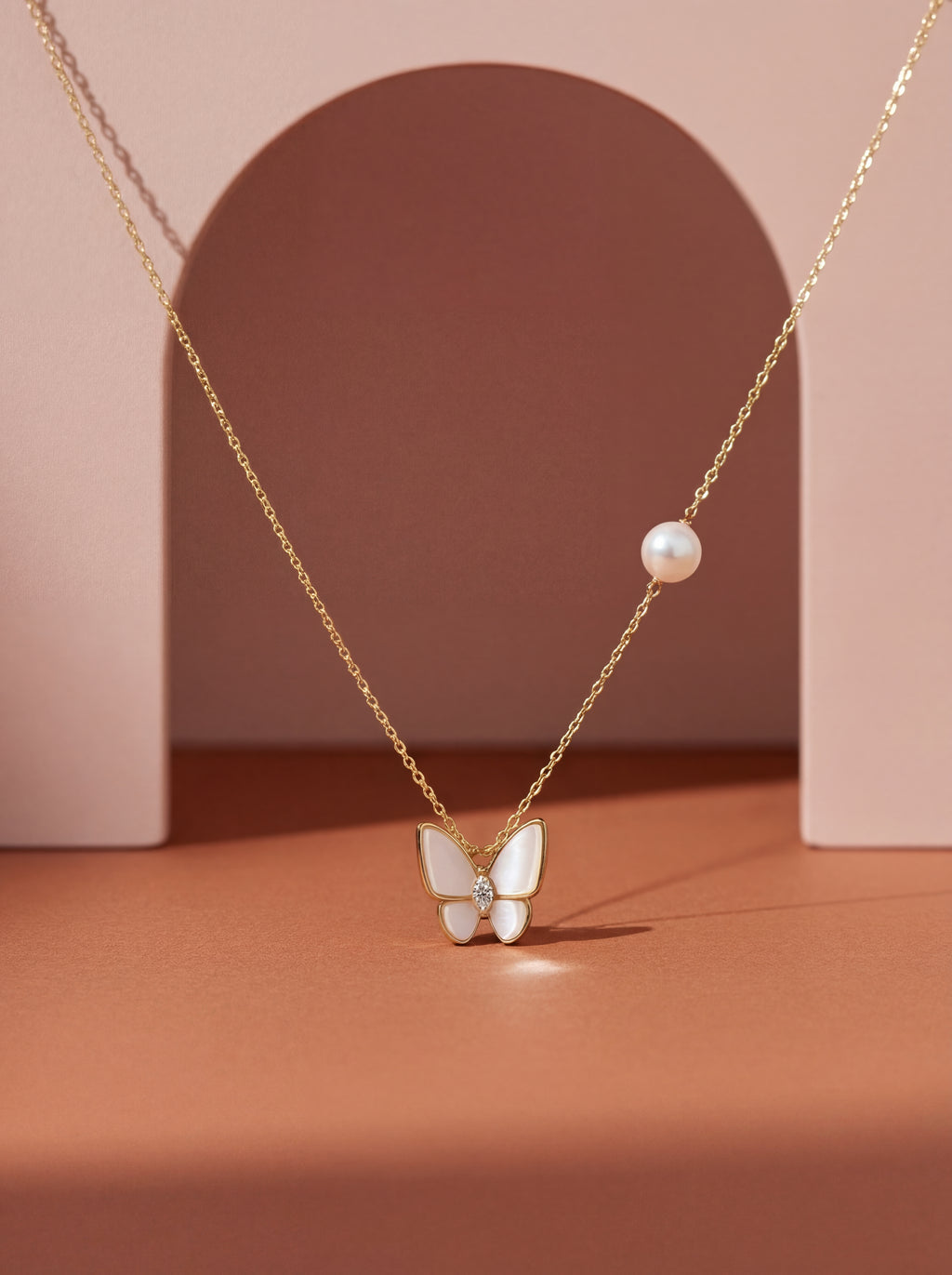 Necklace with a butterfly pendant and pearl on a pink background