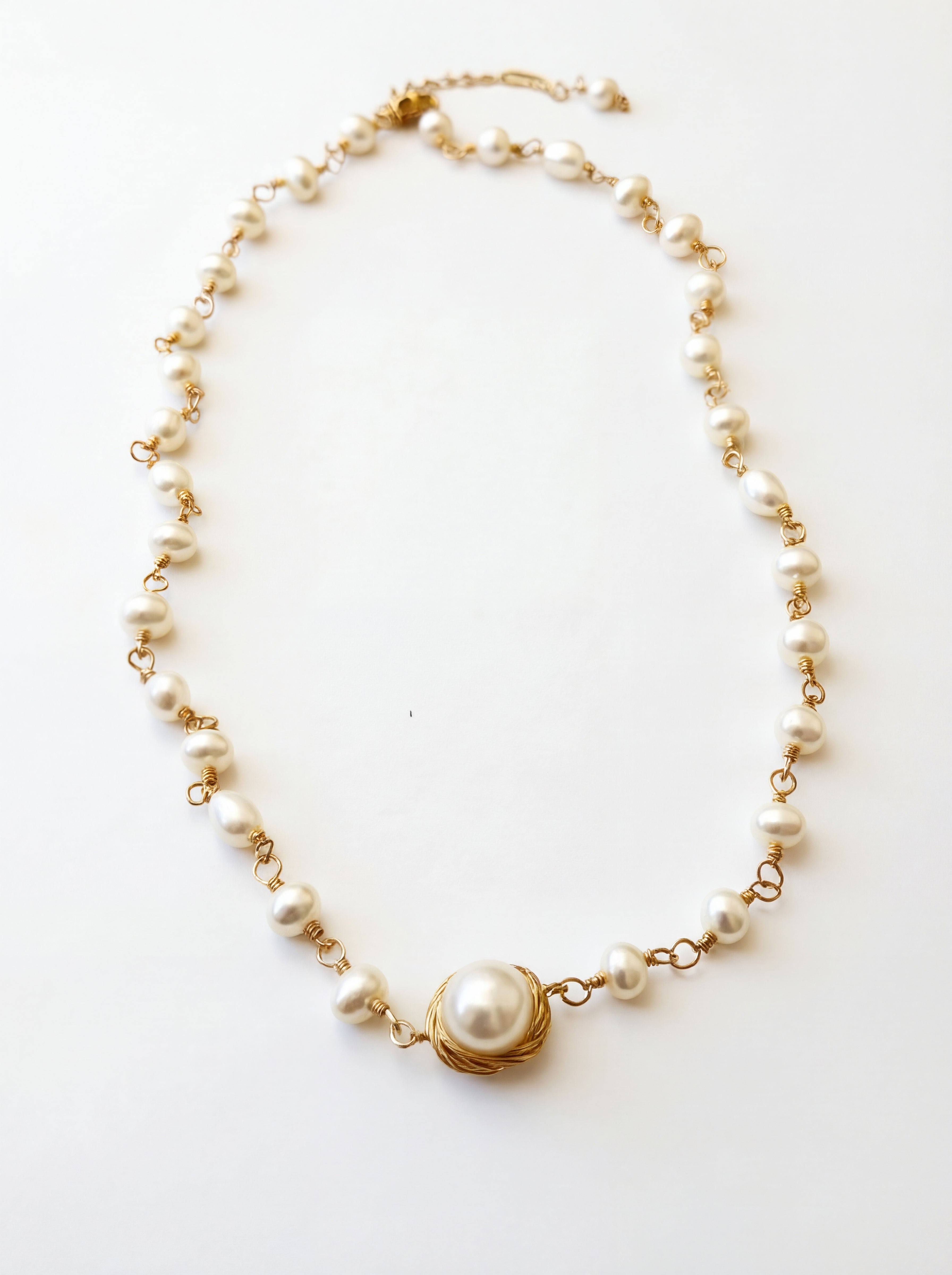 Pearl necklace with gold chain on a white background