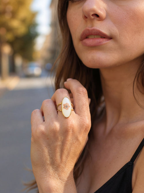 Close-up of a woman's hand wearing a decorative ring outdoors.