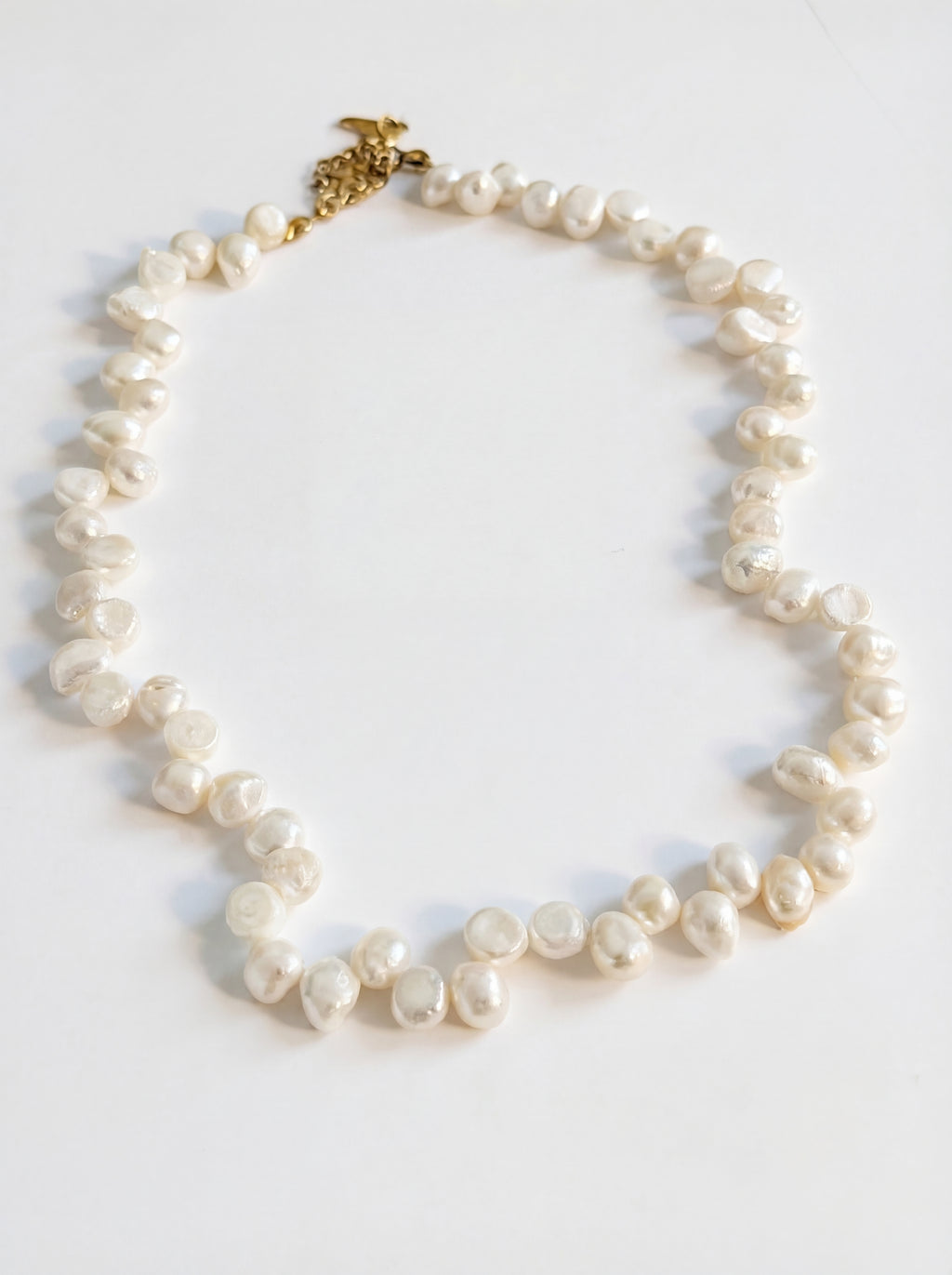 Pearl necklace with a gold clasp on a white background
