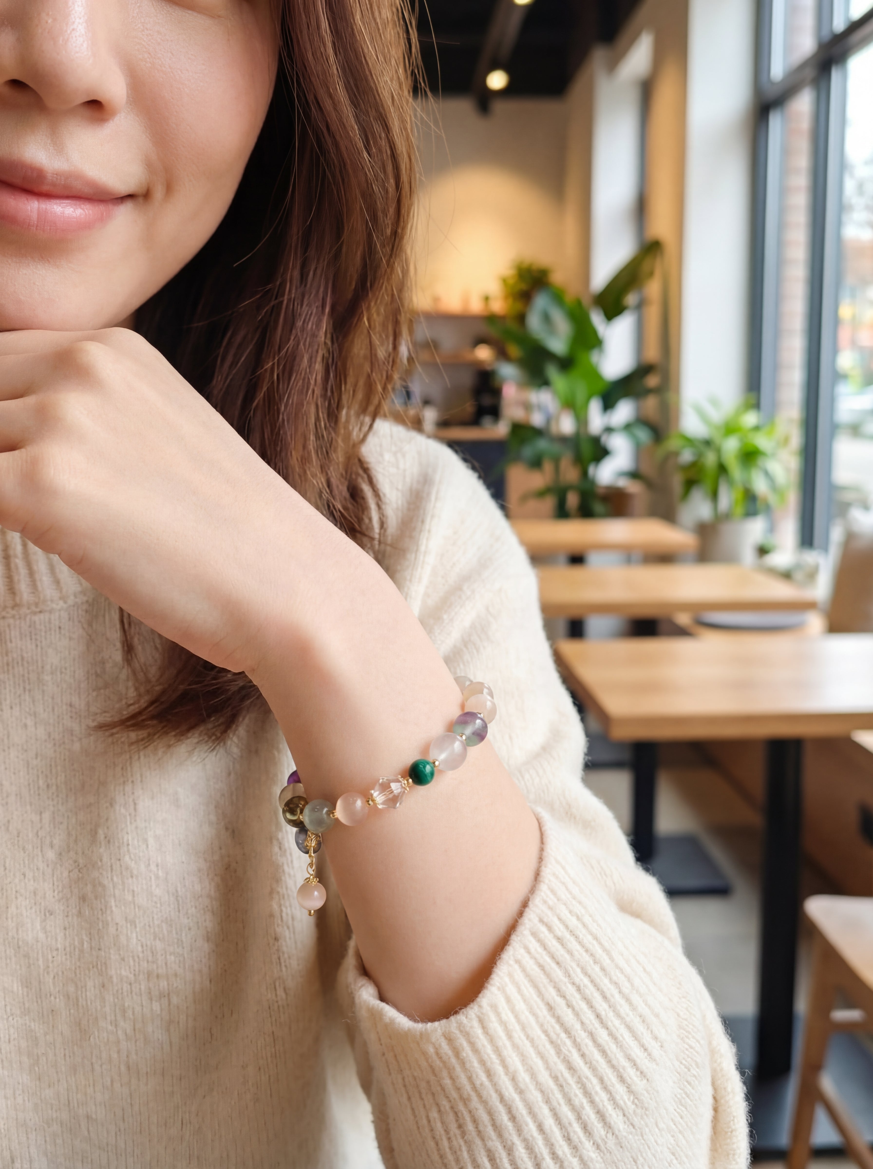 Woman wearing a bracelet with a blurred cafe background