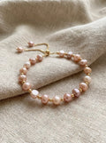 Pearl bracelet with gold accents on a beige fabric background