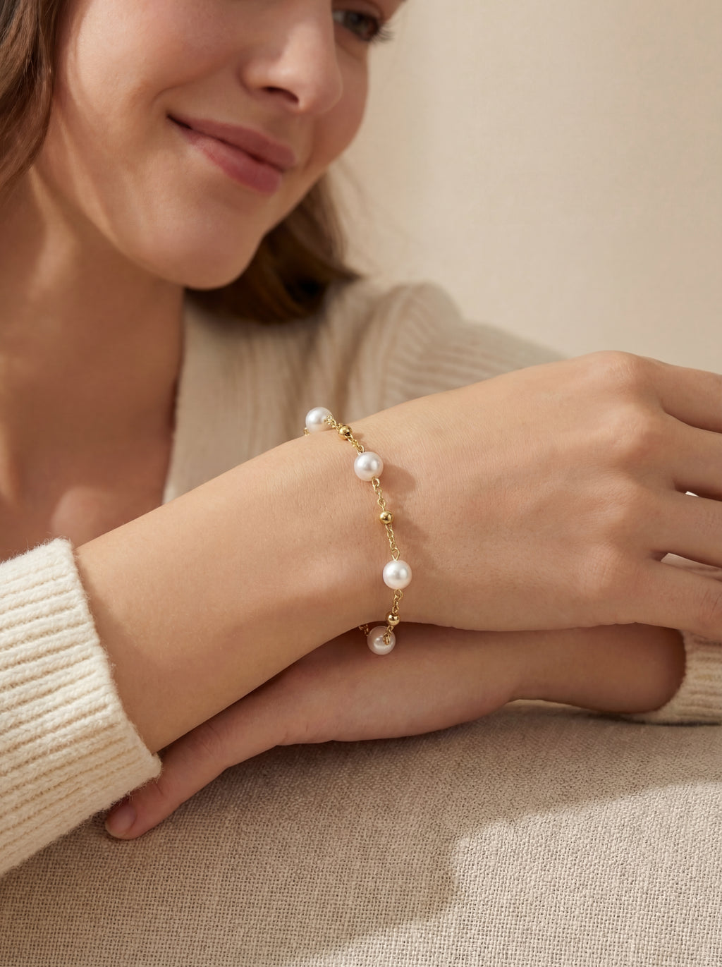 Woman wearing a pearl bracelet on a neutral background