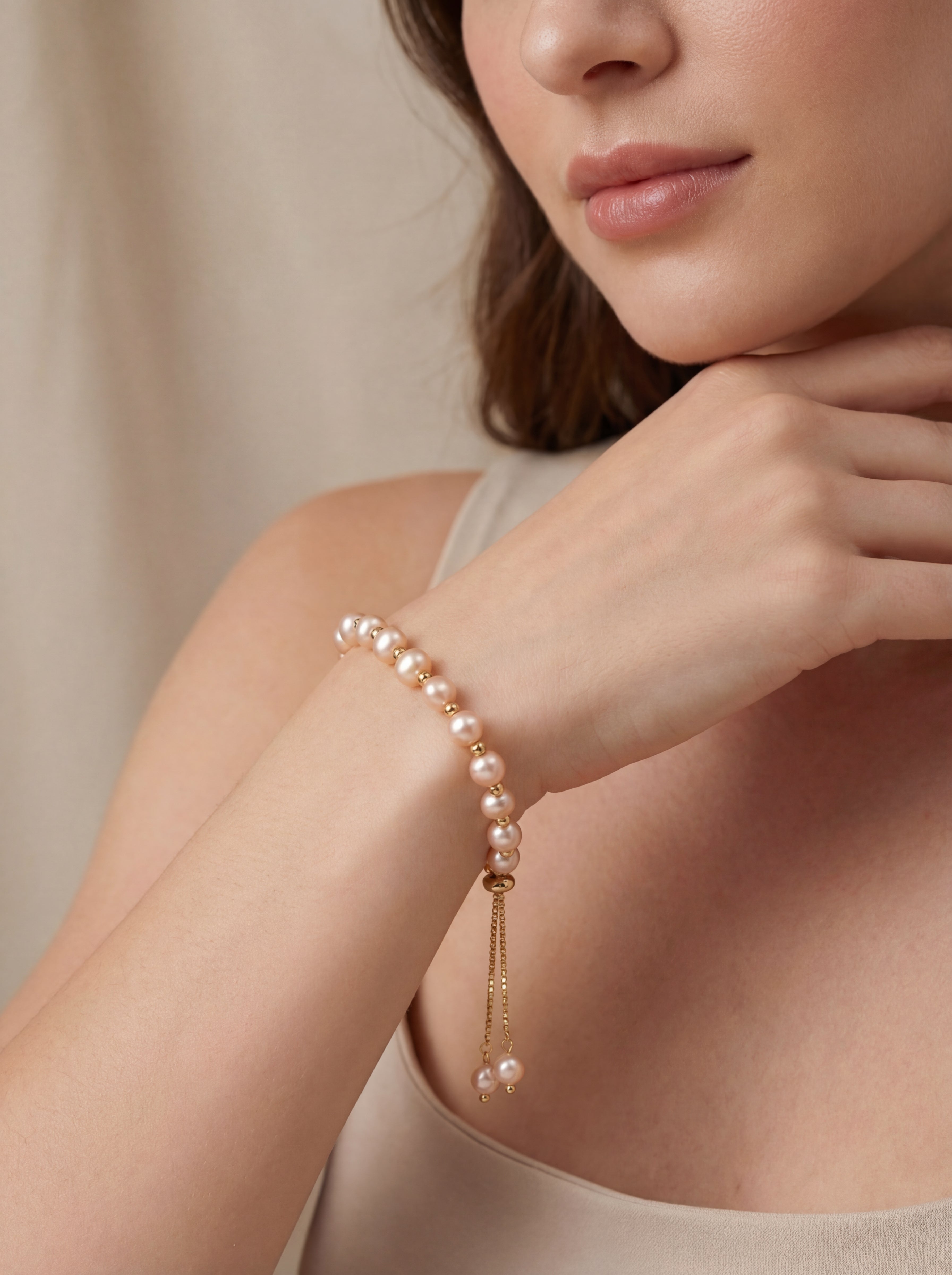 Pearl bracelet on a person's wrist with a neutral background