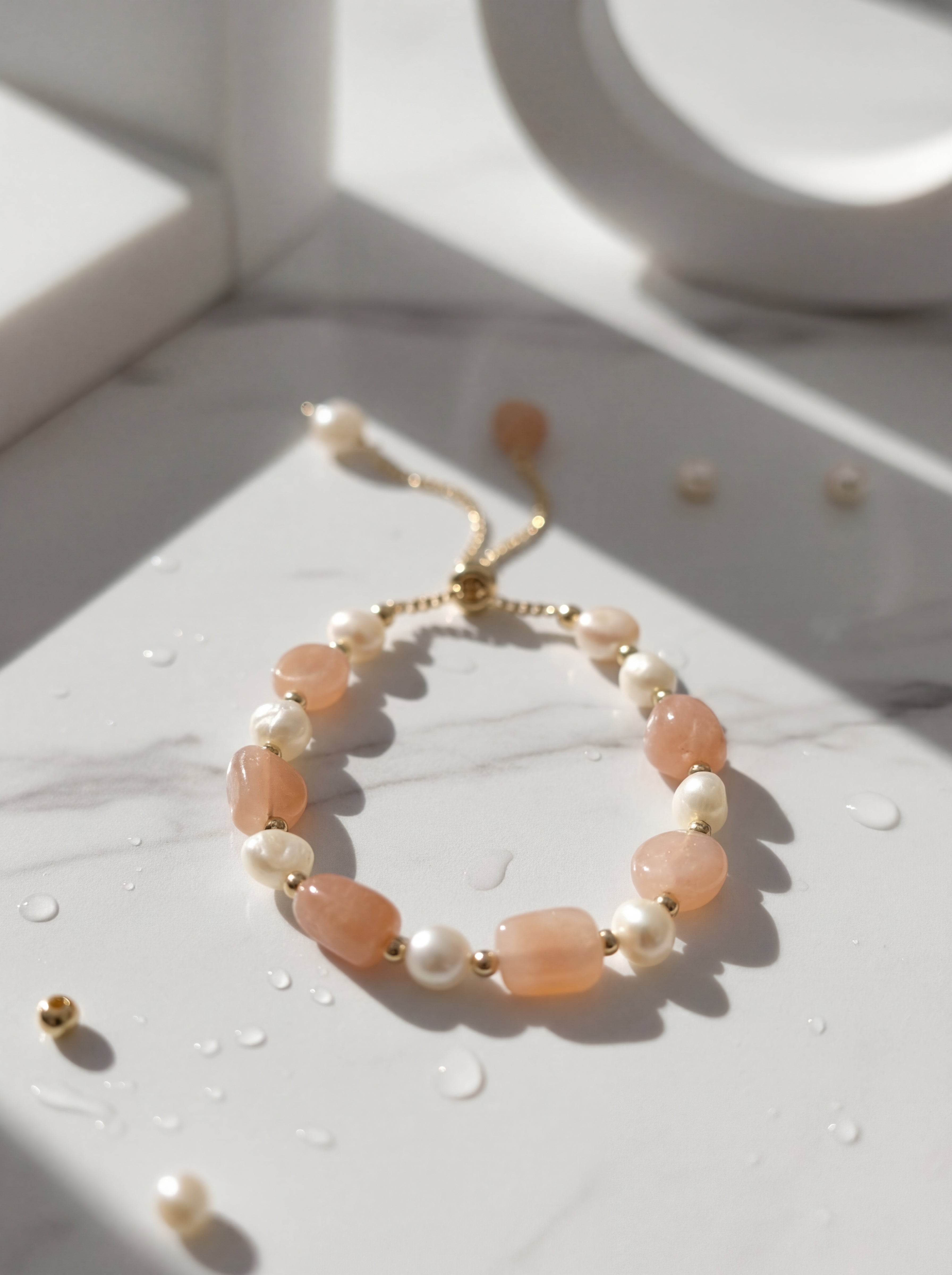 Bracelet with peach and pearl beads on a light surface